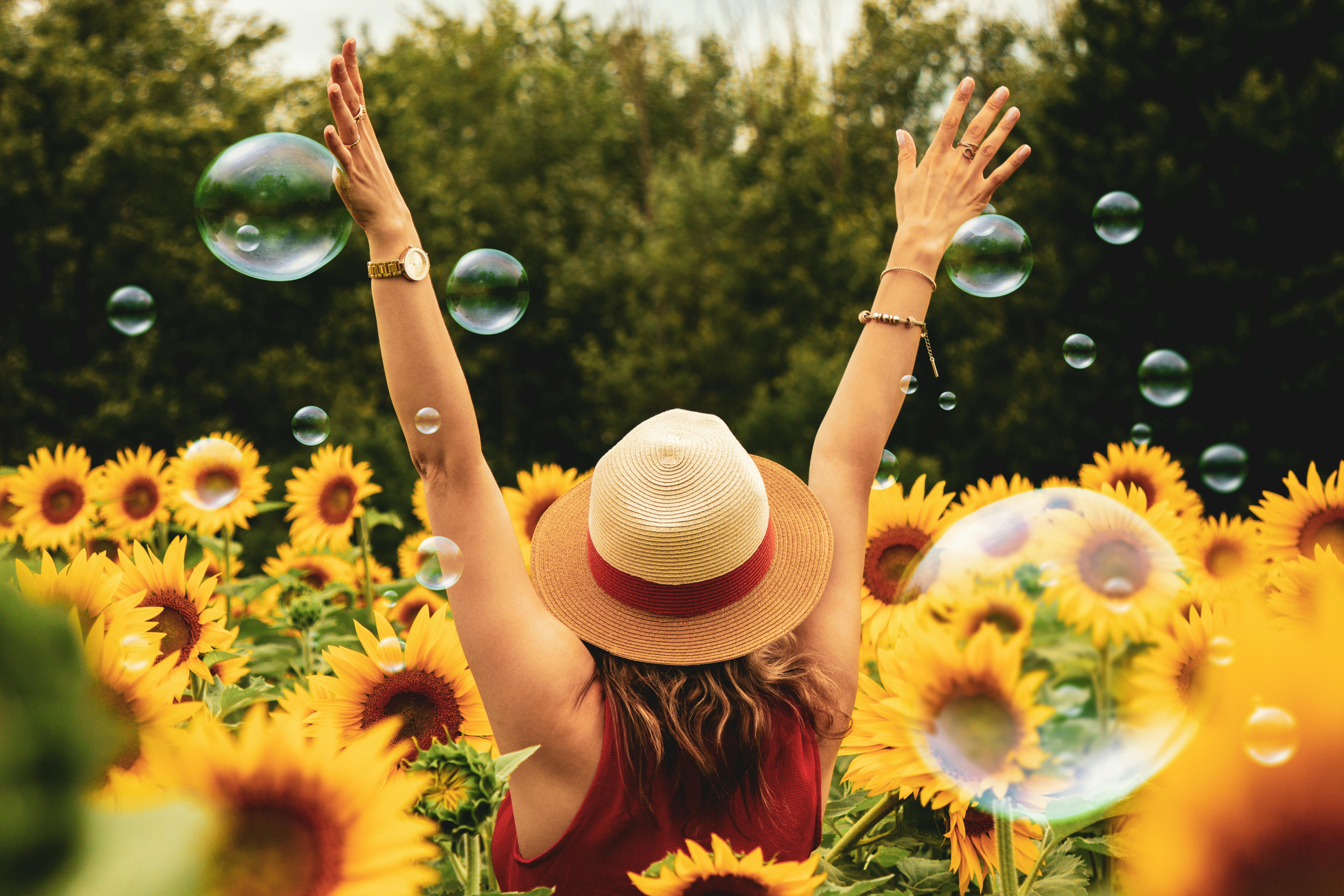 Woman in sunflower field with bubbles